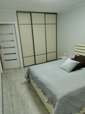 a bedroom with a large bed with glass doors at Butas miesto centre in Šiauliai