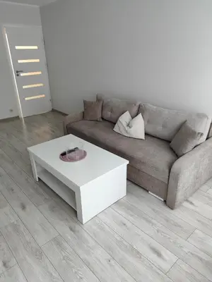 a living room with a couch and a white coffee table at Butas miesto centre in Šiauliai