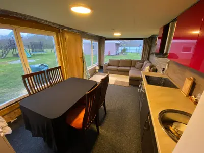 a kitchen and dining room with a table and chairs at Karalgirio žvejų namelis in Karalgiris