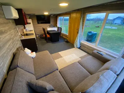 a living room with a couch and a table at Karalgirio žvejų namelis in Karalgiris