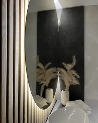a bathroom with a round mirror and a sink at LUX Apartamentai in Marijampolė