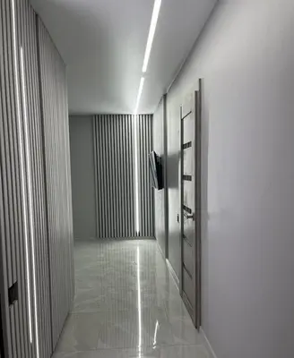 an empty hallway with a door and a television at LUX Apartamentai in Marijampolė