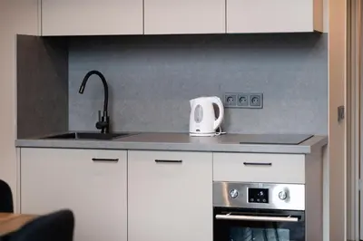 a kitchen with white cabinets and a sink and a stove at Brand New Urban Lofts by Reside Baltic in Vilnius
