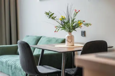 a table with a vase of flowers on it at Brand New Urban Lofts by Reside Baltic in Vilnius