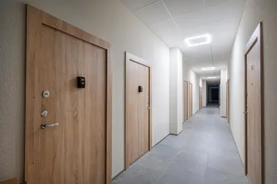 an empty hallway with wooden doors and a tile floor at Brand New Urban Lofts by Reside Baltic in Vilnius