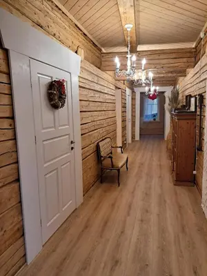 an empty hallway with a white door and a chair at Stebuklėlis in Pakruojis