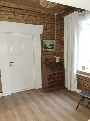 a room with a white door and a wooden wall at Stebuklėlis in Pakruojis