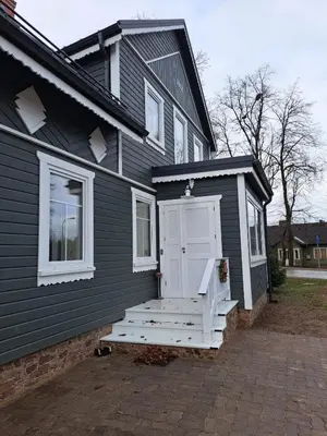 a black house with a white door and a porch at Stebuklėlis in Pakruojis