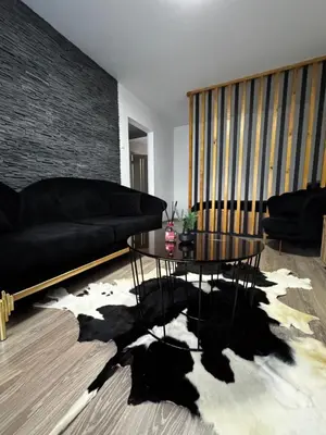 a living room with a black couch and a table at Gold & Black in Kėdainiai