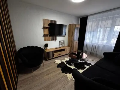 a living room with a couch and a tv at Gold & Black in Kėdainiai