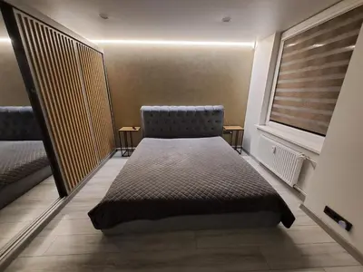 a bed sitting in a room with a window at Kėdainiai Alinos Apartamentai in Kėdainiai