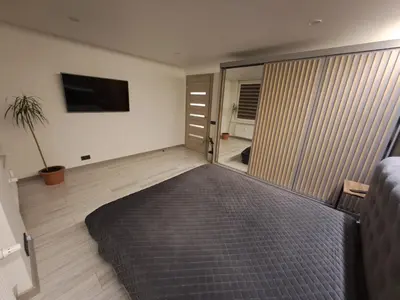a bedroom with a bed and a sliding glass door at Kėdainiai Alinos Apartamentai in Kėdainiai