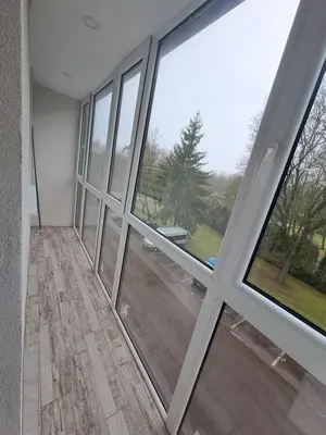 an empty room with large windows in a house at Kėdainiai Alinos Apartamentai in Kėdainiai