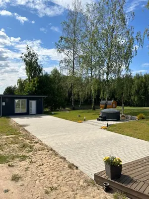 a large patio with a building in a park at Poilsio oazė Stebuliuose in Stebuliai
