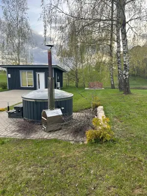 a house with a hot tub in a yard at Poilsio oazė Stebuliuose in Stebuliai