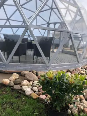 a glass greenhouse with a table and chairs in it at Poilsio oazė Stebuliuose in Stebuliai