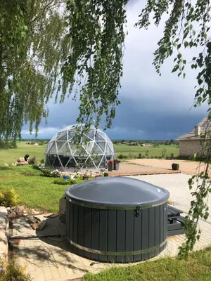 a large metal dome in a field with a park at Poilsio oazė Stebuliuose in Stebuliai