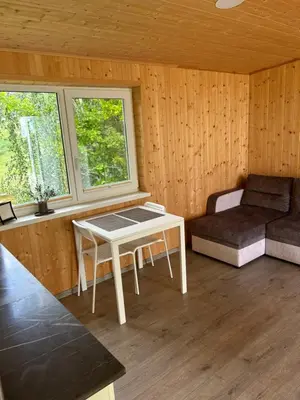 a living room with a table and a couch at Atostogų namelis Stebuliuose in Stebuliai