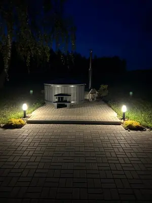 a hot tub in a park at night with lights at Atostogų namelis Stebuliuose in Stebuliai