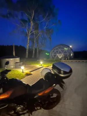 a motorcycle parked on a sidewalk at night at Atostogų namelis Stebuliuose in Stebuliai