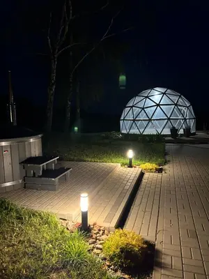 a park with two benches and a glass dome at night at Atostogų namelis Stebuliuose in Stebuliai