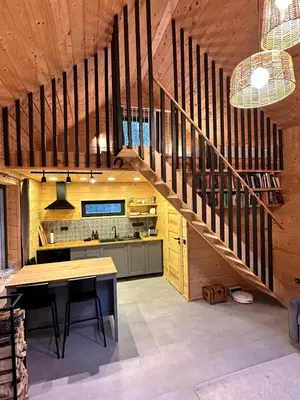 a kitchen with a wooden staircase and a table at Local Forest in Vilnius