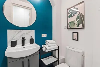 a bathroom with a white sink and a mirror at Blue Oasis and Wizard's Hideaway apartments in Kaunas