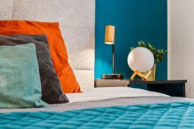 a bedroom with a bed with blue walls and a lamp at Blue Oasis and Wizard's Hideaway apartments in Kaunas