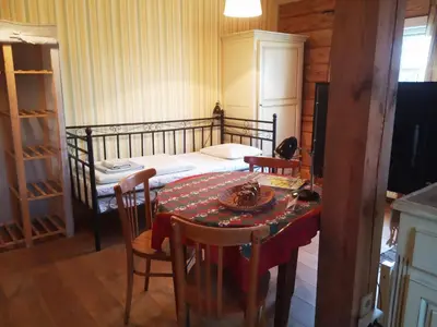 a bedroom with a bed and a table and chairs at Senosios Gegužinės ūkis in Gegužinė