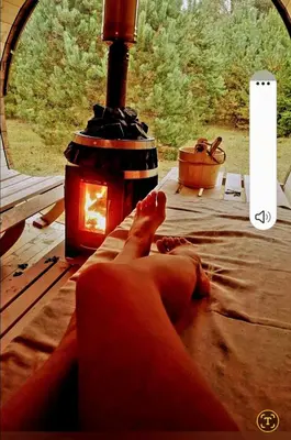 a person laying on a bed with their feet up next to a lamp at Šilas in Degučiai