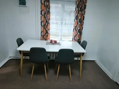 a table and chairs in a room with a window at Kambarių nuoma 