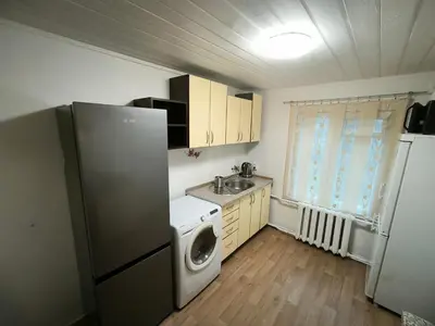 a kitchen with a refrigerator and a washing machine at Kambarių nuoma 
