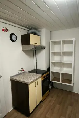 a kitchen with a counter and a clock on the wall at Kambarių nuoma 