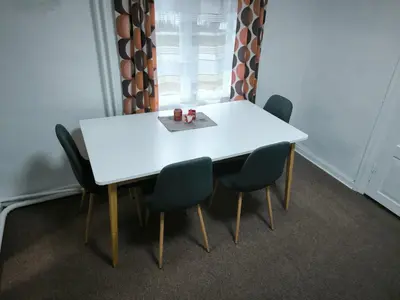 a white table with four chairs and a window at Kambarių nuoma 
