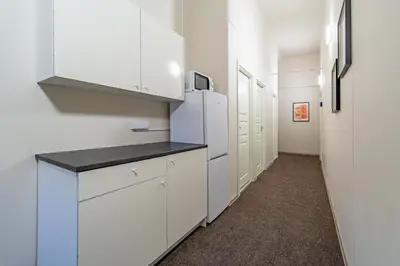 a kitchen with white cabinets and a refrigerator at Urban Style Old Town in Kaunas