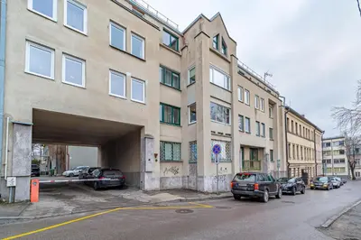 a building with cars parked in a parking lot at Urban Style Old Town in Kaunas