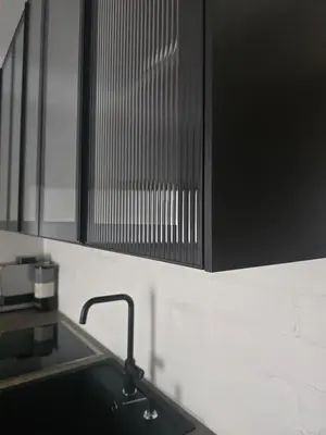 a kitchen with a sink and a black cabinet at Downtown Apartment Rentals in Šiauliai