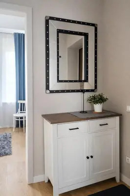 a mirror on top of a white dresser in a room at Downtown Apartment Rentals in Šiauliai