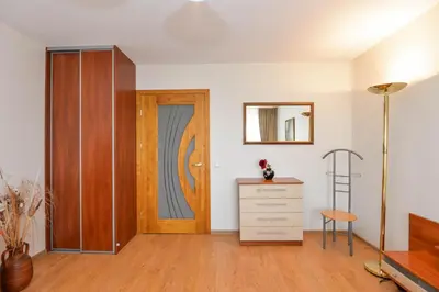 a room with a door and a dresser and a chair at Apartment with air conditioning in the Center in Druskininkai