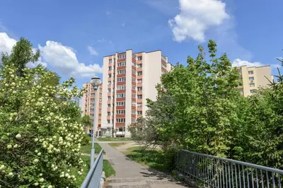 a tall apartment building with trees in front of it at Apartment with air conditioning in the Center in Druskininkai