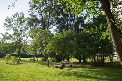 a park with a bench and trees and a playground at Apartment with air conditioning in the Center in Druskininkai