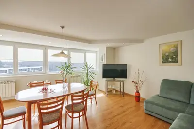 a living room with a table and chairs and a television at Apartment with air conditioning in the Center in Druskininkai