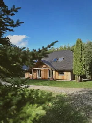 a large wooden house with a gambrel roof at Pakaso sodyba in Kirdeikiai