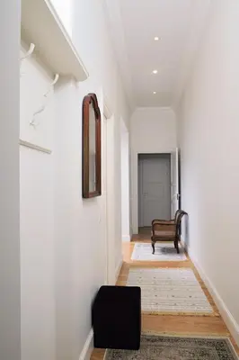 a hallway with a chair and a mirror on a wall at Cosy Old Vilnius in Vilnius