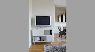 a living room with a television on a white cabinet at Cosy Old Vilnius in Vilnius