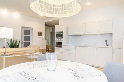 a kitchen and living room with a table and chairs at Cute apartment Konstitucijos ave in Vilnius