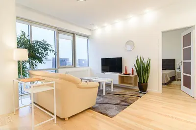 a living room with a couch and a tv at Cute apartment Konstitucijos ave in Vilnius