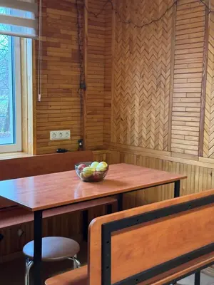 a wooden table with a bowl of fruit on it at Park Hostel in Šiauliai