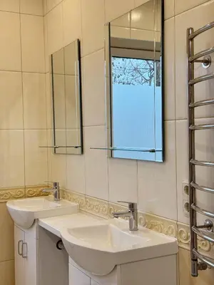 a bathroom with two sinks and a mirror at Park Hostel in Šiauliai