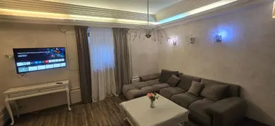 a living room with a couch and a tv at Apartamentai su jacuzzi in Vilnius